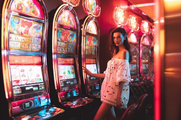 GOOD11111 Slots — Thousands of exciting themes and jackpots A stylish woman beside vibrant slot machines displaying glowing sevens, showcasing the variety of top slots at GOOD11111.